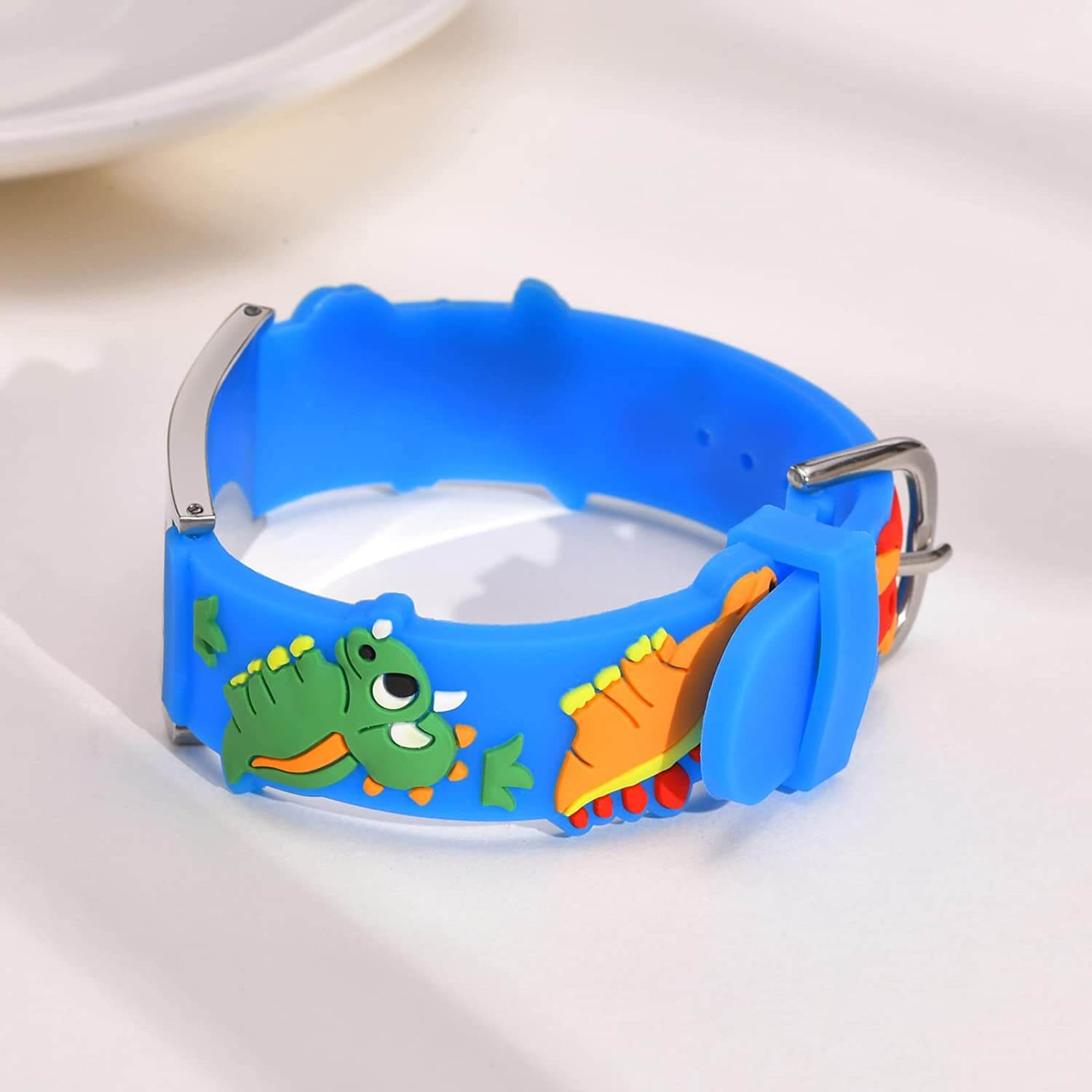 Side view of medical alert bracelet for a child. Bracelet band is made of blue silicone with a dinosaur design.